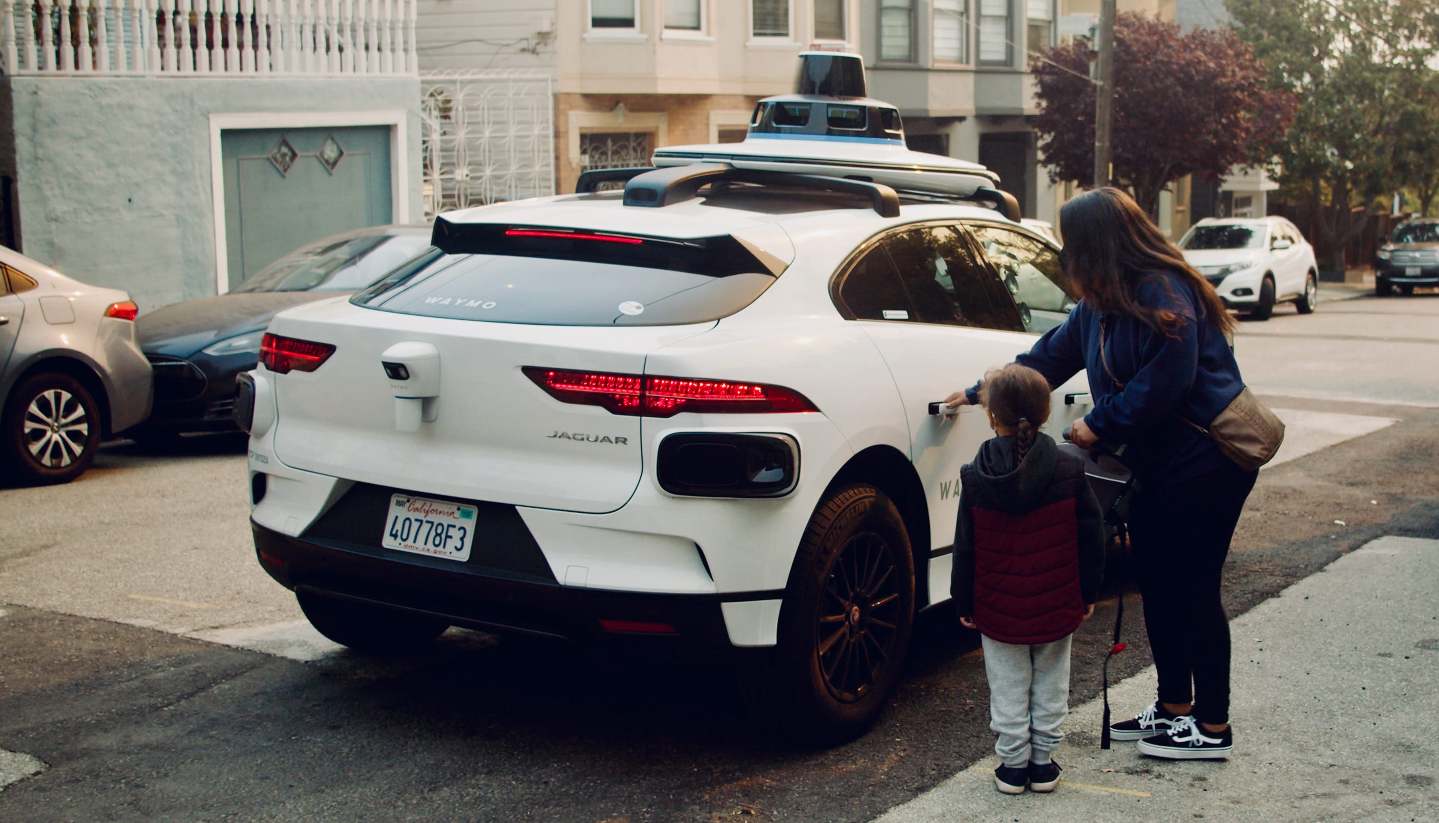 Bilde av noen som går inn i en Waymo bil.